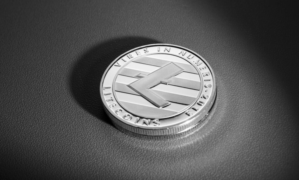 Dramatic close-up of a Litecoin coin on a textured surface, showcasing its design details.