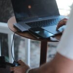 a man sitting at a table using a laptop computer