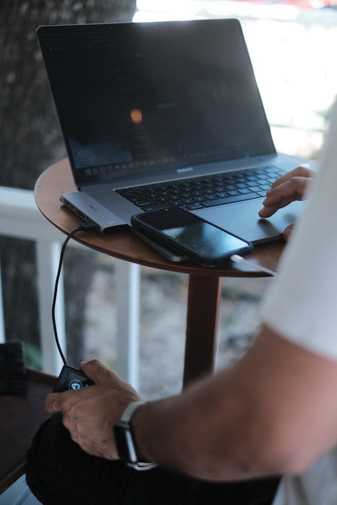 a man sitting at a table using a laptop computer