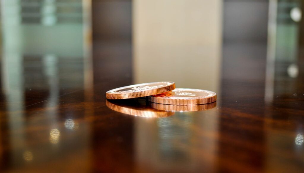 coin, token, fake money, reflection, table, light, brown money, token, token, token, token, token