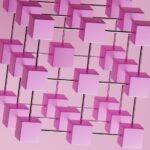 a bunch of pink cubes hanging from a pink wall