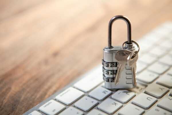 Padlock and keys resting on a computer keyboard.