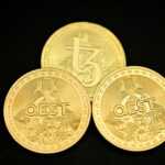 a close up of three gold coins on a black surface